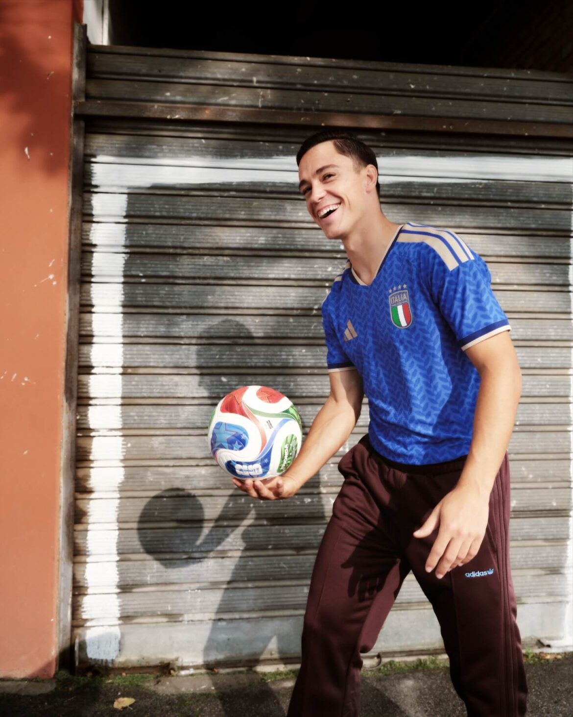 Jogador da Seleção Italiana vestindo camisa azul Adidas 2026 com detalhes dourados