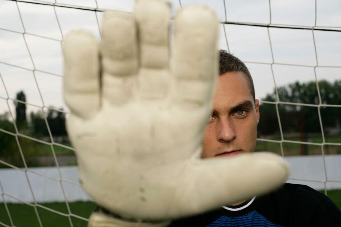 Goleiro de futebol segurando uma luva durante a partida