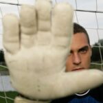 Goleiro de futebol segurando uma luva durante a partida